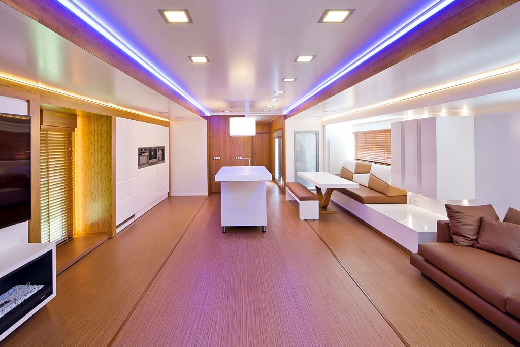 luxe woontrailer met moderne meubels op maat gemaakt van hout en leren banken