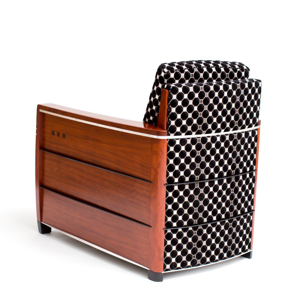 achteraanzicht houten fauteuil met stoffen bekleding met een zwartwit patroon dat doorloopt over de achterkant